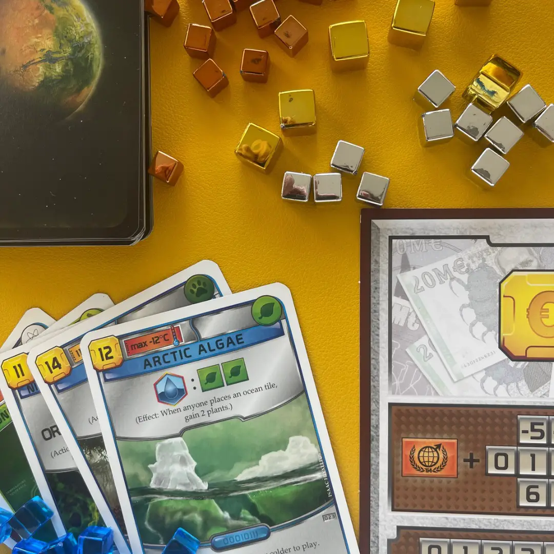 Pieces from the game Terraforming Mars on a yellow pad - feature image for games like Terraforming Mars post